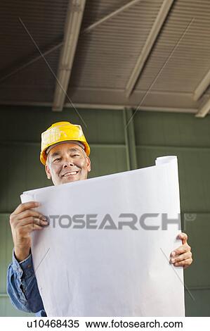 Stock Photography - Portrait of architect holding blueprint. Fotosearch