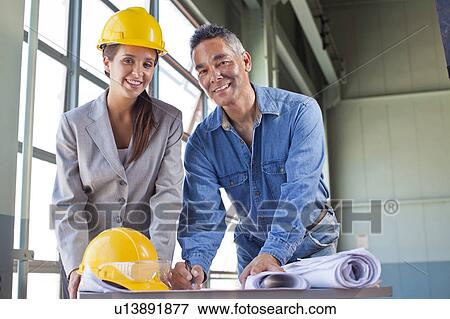 Portrait of architects drawing blueprint View Large Photo Image Stock Photo - Portrait of architects drawing blueprint. Fotosearch