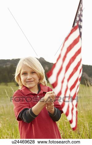 Stock Photo - Portrait of boy (6-7) waving American flag. Fotosearch