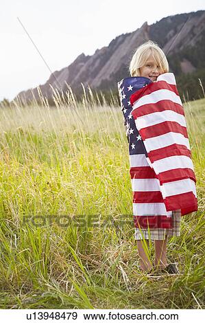 Portrait of boy (6-7) wrapped in American flag View Large Photo Image Stock Photo - Portrait of boy (6-7) wrapped in American flag. Fotosearch