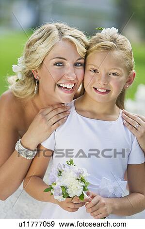 Stock Photo - Portrait of bride with flower girl (10-11) at wedding reception. Fotosearch