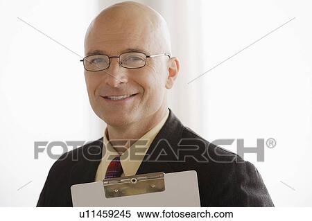 Stock Photography - Portrait of business man holding clipboard. Fotosearch