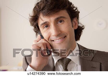 Stock Image - Portrait of businessman talking on phone. Fotosearch
