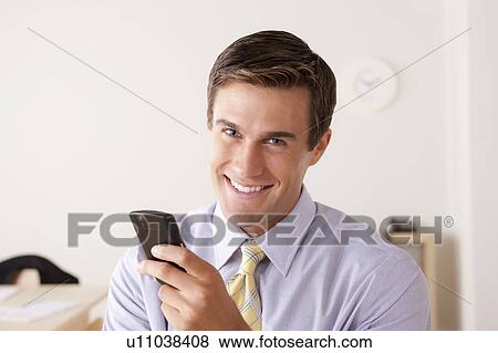 Portrait of businessman text-messaging View Large Photo Image Stock Photo - Portrait of businessman text-messaging. Fotosearch