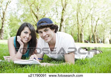 Portrait of couple lying on grass View Large Photo Image Stock Image - Portrait of couple lying on grass. Fotosearch
