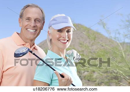 Stock Photograph - Portrait of couple on golf course. Fotosearch
