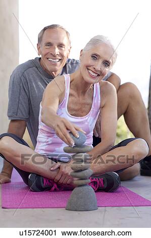 Stock Image - Portrait of couple stacking pebbles. Fotosearch