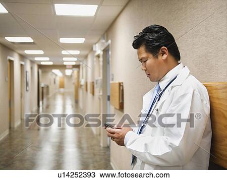 Stock Image - Portrait of doctor with mobile phone. Fotosearch