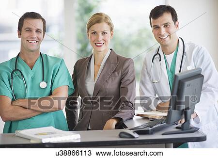 Portrait of doctors and businesswoman at nurse's station View Large Photo Image Stock Image - Portrait of doctors and businesswoman at nurse's station. Fotosearch