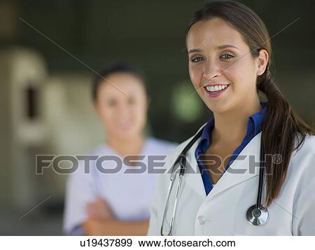 Stock Photo - Portrait of female doctor, healthcare worker in background. Fotosearch