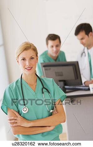 Portrait of female doctor in front of nurse's station View Large Photo Image Stock Image - Portrait of female doctor in front of nurse's station. Fotosearch