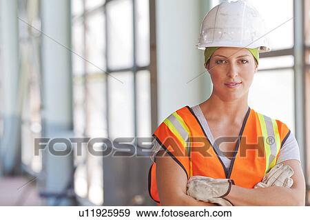 Stock Photo - Portrait of female manual worker wearing hardhat. Fotosearch