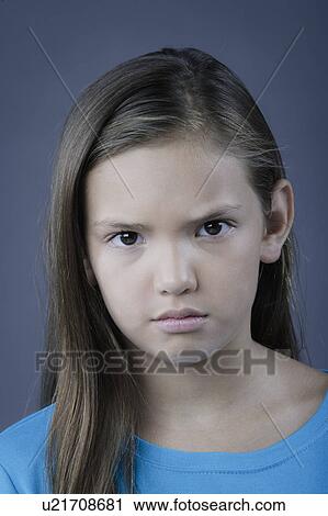Stock Image - Portrait of girl (8-9) looking angry, studio shot. Fotosearch