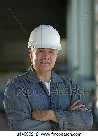 Stock Image - Portrait of industrial worker wearing hardhat. Fotosearch