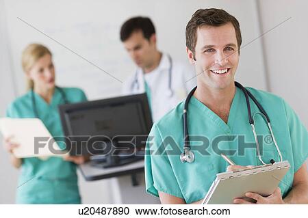 Portrait of male doctor in front of nurse's station View Large Photo Image Stock Image - Portrait of male doctor in front of nurse's station. Fotosearch