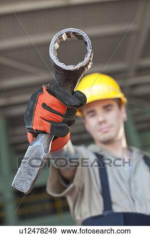 Portrait of male manual worker holding tool View Large Photo Image Stock Photo - Portrait of male manual worker holding tool. Fotosearch