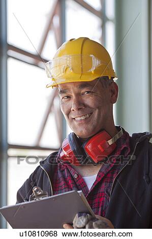 Stock Photo - Portrait of male manual worker wearing hardhat. Fotosearch