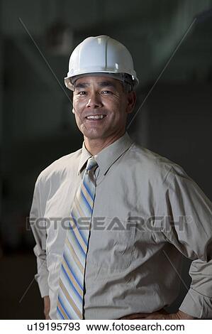 Stock Image - Portrait of male technician wearing hardhat. Fotosearch