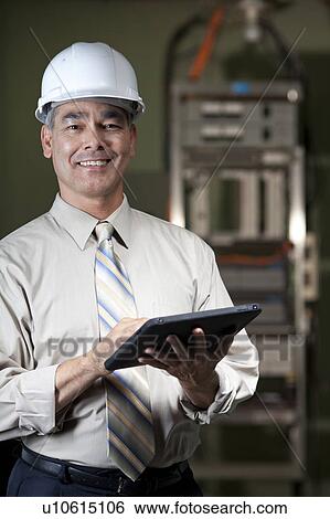 Stock Photograph - Portrait of male technician wearing hardhat. Fotosearch