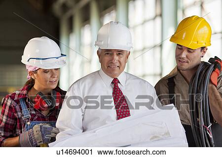 Portrait of manual workers and manager looking at blueprint View Large Photo Image Stock Image - Portrait of manual workers and manager looking at blueprint. Fotosearch