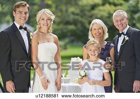 Stock Image - Portrait of married couple, parents and flower girl (10-11). Fotosearch