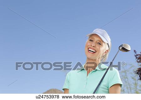 Stock Photo - Portrait of mature woman holding golf club. Fotosearch
