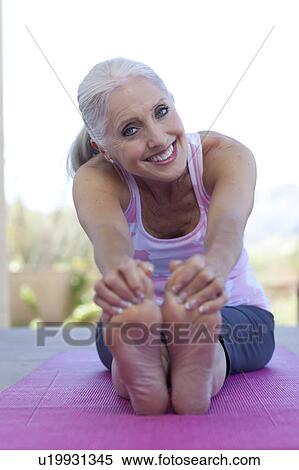 Portrait of mature woman stretching View Large Photo Image Stock Photography - Portrait of mature woman stretching. Fotosearch