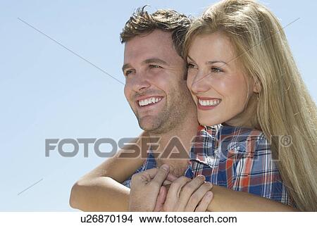 Picture - Portrait of mid adult couple against blue sky. Fotosearch