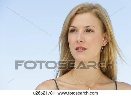 Portrait of mid adult woman against blue sky View Large Photo Image Stock Image - Portrait of mid adult woman against blue sky. Fotosearch