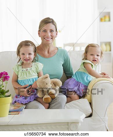 Portrait of mother with daughters (2-3) on sofa View Large Photo Image Picture - Portrait of mother with daughters (2-3) on sofa. Fotosearch