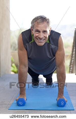 Stock Image - Portrait of senior man doing push-ups. Fotosearch