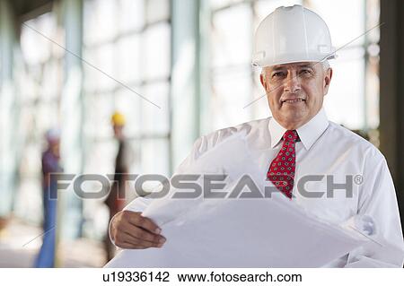 Portrait of senior man wearing tie and hardhat, holding blueprint View Large Photo Image Stock Image - Portrait of senior man wearing tie and hardhat, holding blueprint. Fotosearch