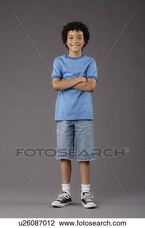 Stock Image - Portrait of smiling boy (8-9), studio shot. Fotosearch