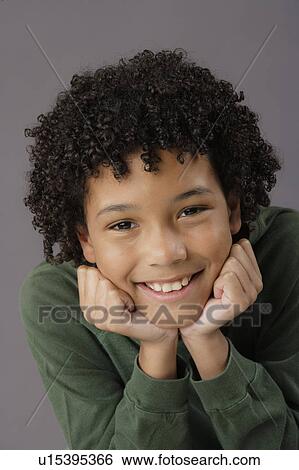 Stock Photograph - Portrait of smiling boy (8-9), studio shot. Fotosearch