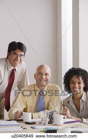 Stock Photo - Portrait of smiling business people at meeting. Fotosearch