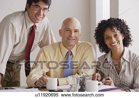 Stock Photography - Portrait of smiling business people at meeting. Fotosearch