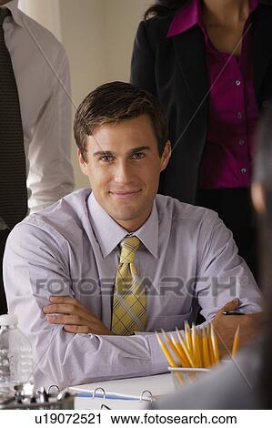 Stock Image - Portrait of smiling businessman in office. Fotosearch
