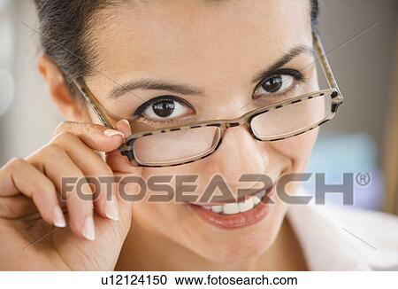 Stock Image - Portrait of smiling businesswoman wearing glasses. Fotosearch