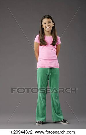 Stock Image - Portrait of smiling girl (8-9), studio shot. Fotosearch