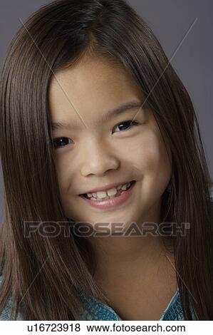 Stock Photo - Portrait of smiling girl (8-9), studio shot. Fotosearch