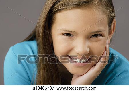 Stock Photo - Portrait of smiling girl (8-9), studio shot. Fotosearch