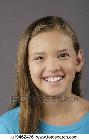 Stock Photograph - Portrait of smiling girl (8-9), studio shot. Fotosearch