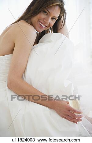 Stock Image - Portrait of smiling woman in wedding dress. Fotosearch