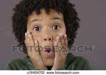 Stock Image - Portrait of surprised boy (8-9), studio shot. Fotosearch