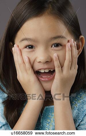 Stock Photo - Portrait of surprised girl (8-9), studio shot. Fotosearch