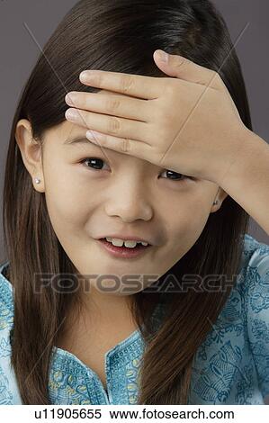 Stock Photography - Portrait of surprised girl (8-9), studio shot. Fotosearch