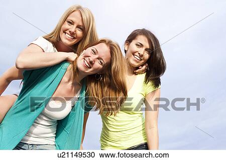 Stock Image - Portrait of three young women hanging out. Fotosearch
