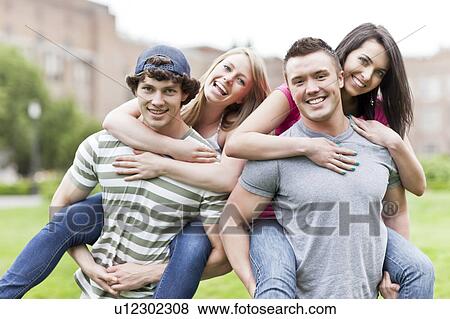 Stock Photo - Portrait of two couples piggybacking on campus. Fotosearch