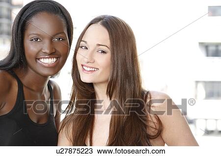 Stock Image - Portrait of two young women smiling. Fotosearch