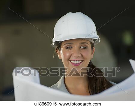 Portrait of woman wearing hardhat reading blueprint View Large Photo Image Stock Photography - Portrait of woman wearing hardhat reading blueprint. Fotosearch